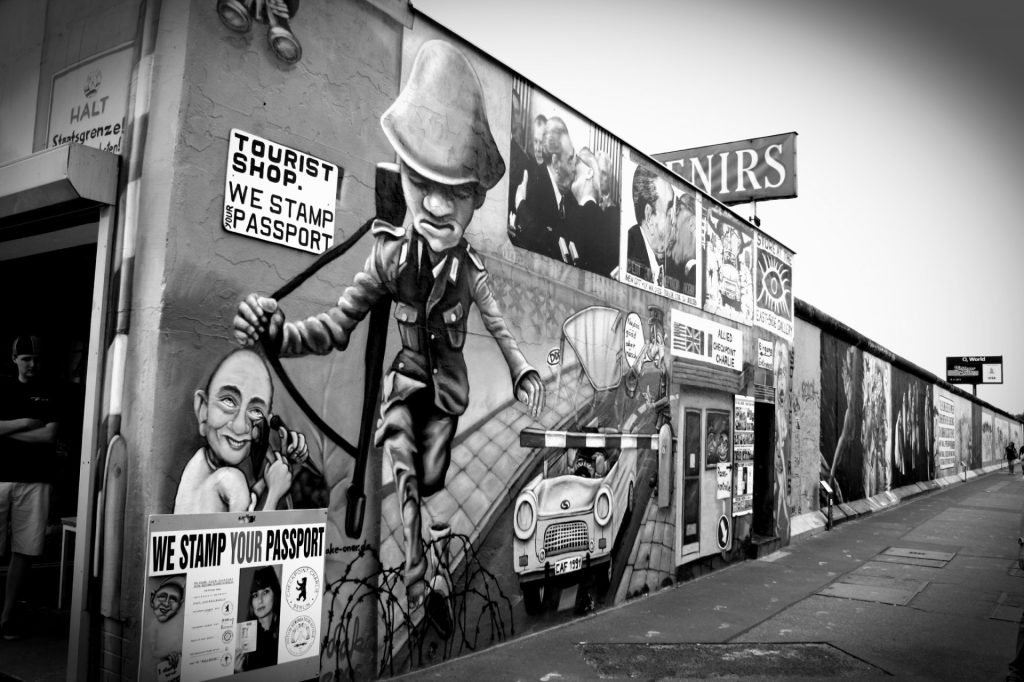 A black and white image of artwork on a section of The Berlin Wall